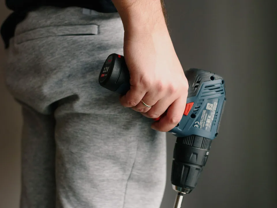 A handyman holding a cordless drill during a home repair